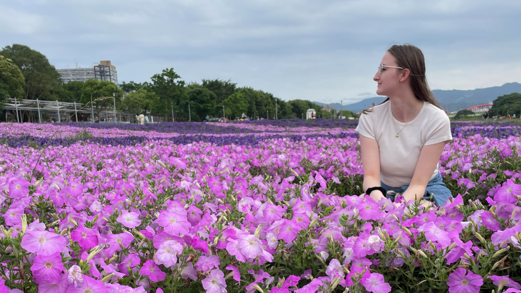 Photo of a woman in a field of purple flowers in Taiwan for a post on How To Recover from Travel Burnout