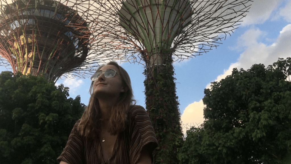 A photo of a woman looking up at the flowers by the bay in Singapore for a post on how to overcome travel burnout