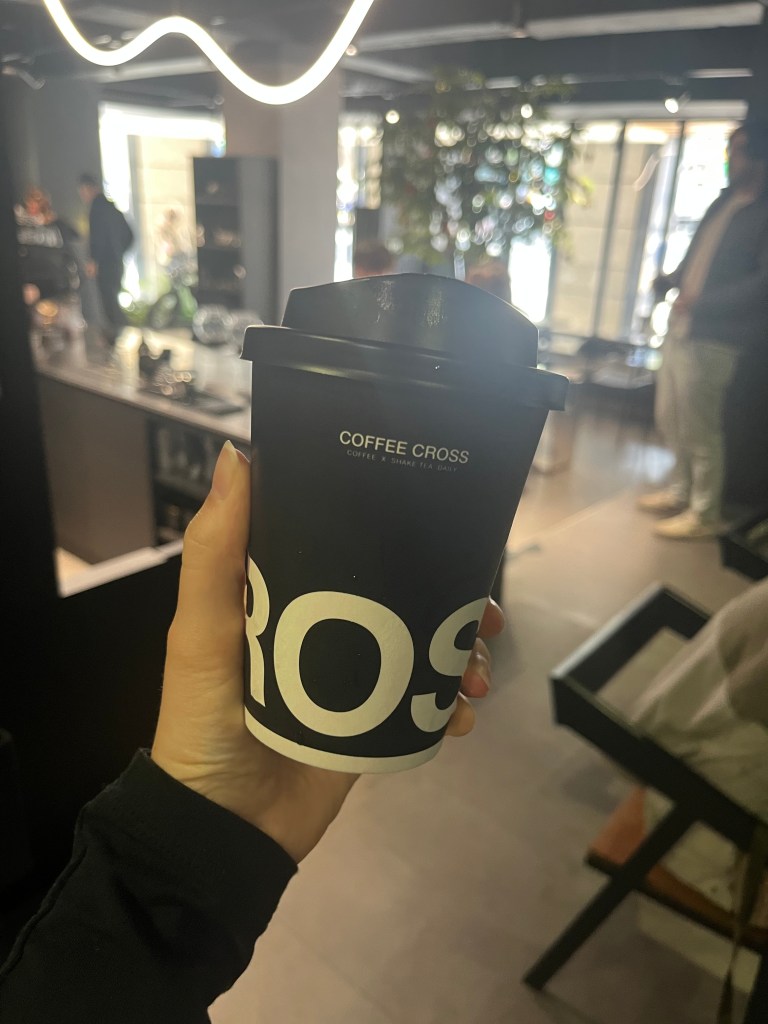 Photo of hand holding a coffee cup in Coffee XOver cafe in Taipei